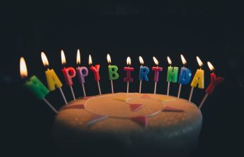 Event at THEA Mackenzie Beach Birthday Magic – Light, Cake, and Celebration Event at THEA Mackenzie Beach. A close-up of a birthday cake with lit candles spelling “Happy Birthday,” representing festive celebrations at THEA.